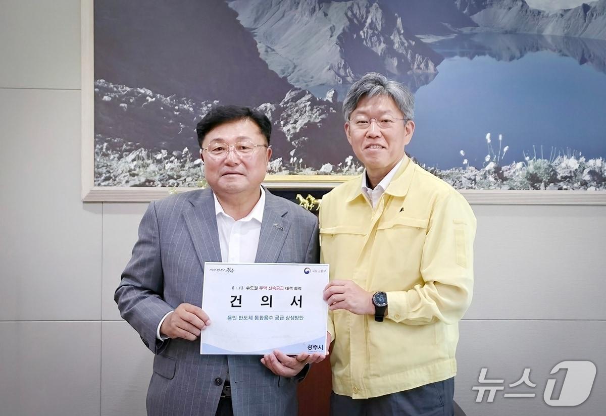 본문 이미지 - 박관열 광주시장(왼쪽)이 20일 김이탁 국토교통부 제1차관에게 광주역세권 일대 공공주택지구 추가 지정과 국가산업단지 조성을 골자로 하는 건의서를 전달했다.(광주시 제공)/뉴스1