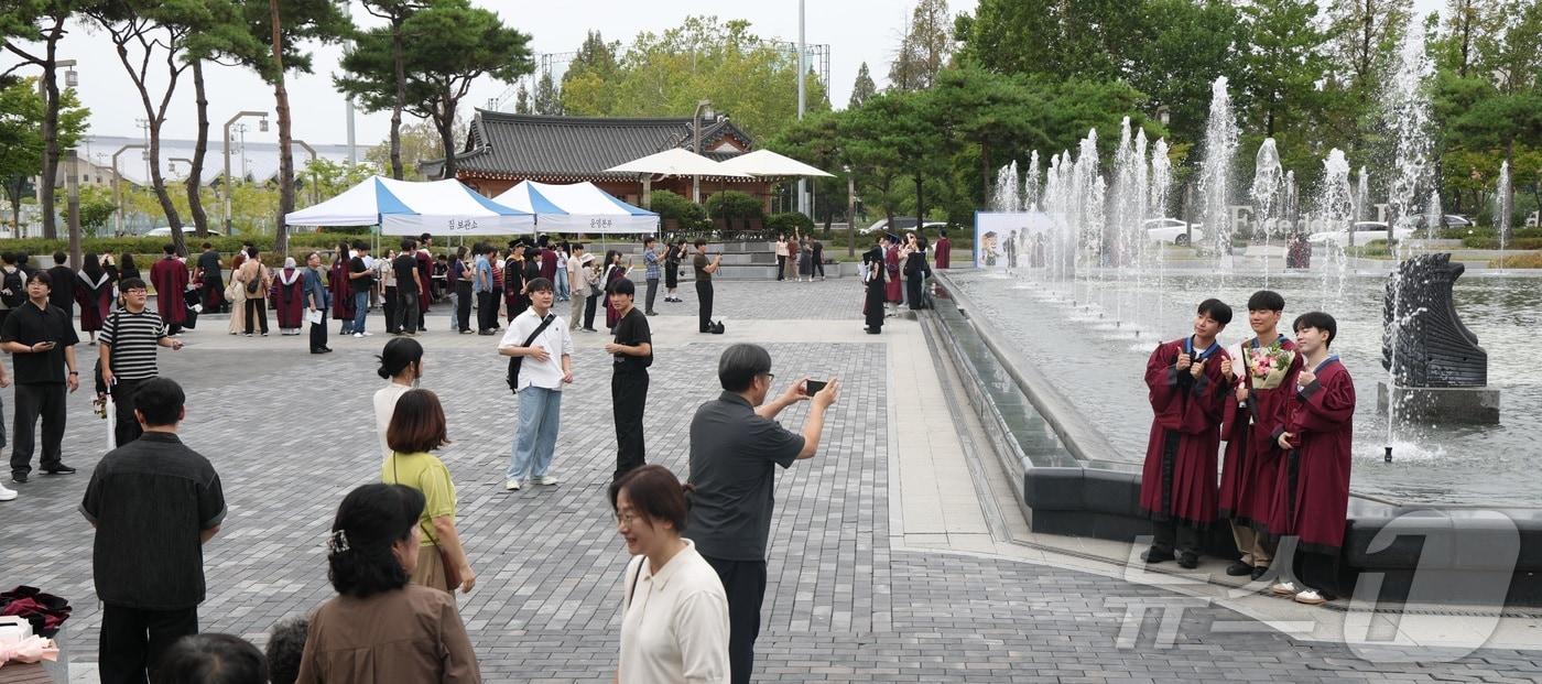 본문 이미지 - 2025학년도 후기 전북대학교 학위수여식 날인 21일 전북 전주시 전북대 문회루에서 졸업생들이 기념촬영을 하고 있다. 2026.8.21 ⓒ 뉴스1 유경석 기자