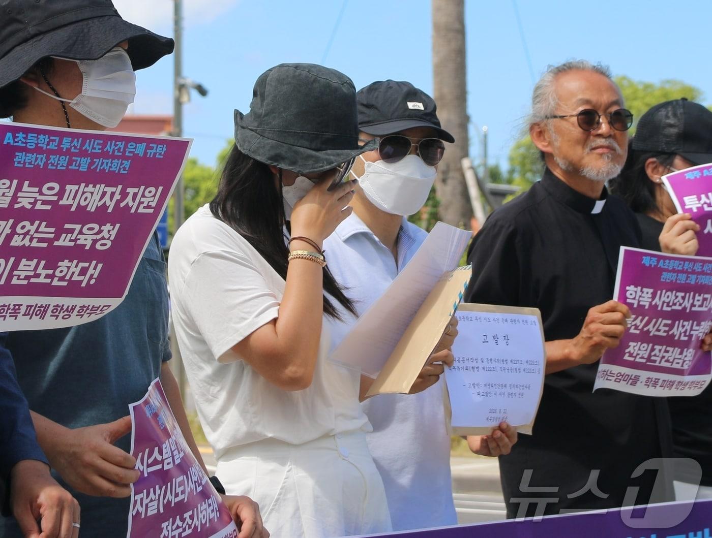 본문 이미지 - 제주 A 초등학교의 투신 시도 사건의 피해 학생 모친이 21일 제주경찰청 앞에서 진행된 고발 기자회견에서 눈물을 훔치고 있다. A 초등학교에서는 지난해 11월 집단 괴롭힘을 당하던 학생이 투신 시도를 한 것으로 알려져 파장이 일고 있다.2026.8.21 ⓒ 뉴스1 홍수영 기자