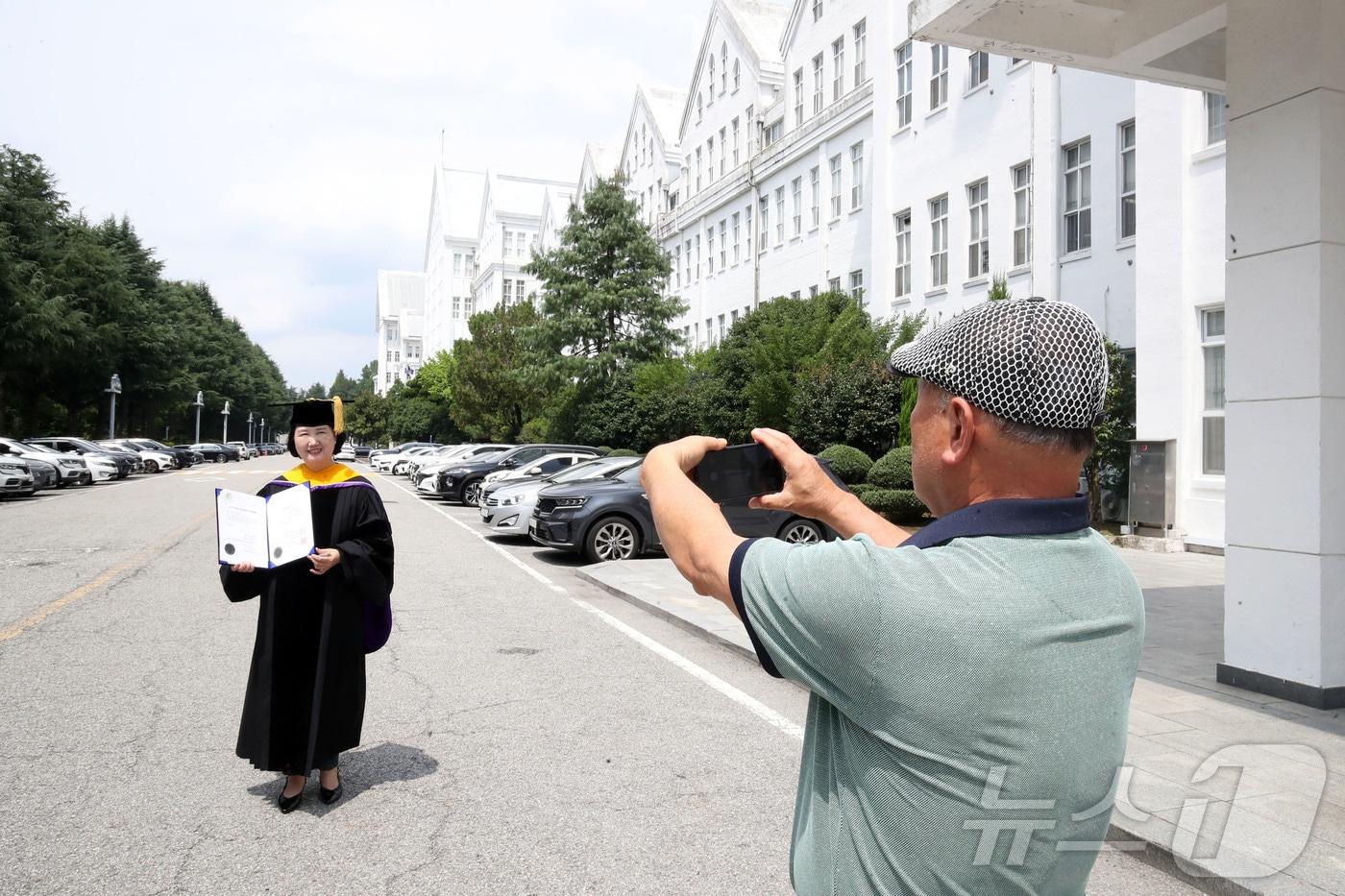본문 이미지 - 21일 오후 전남광주 동구 조선대학교 본관에서 2026학년도 하계 학위증서를 수령한 졸업생이 기념사진을 촬영하고 있다. 2026.8.21 ⓒ 뉴스1 조수민 기자