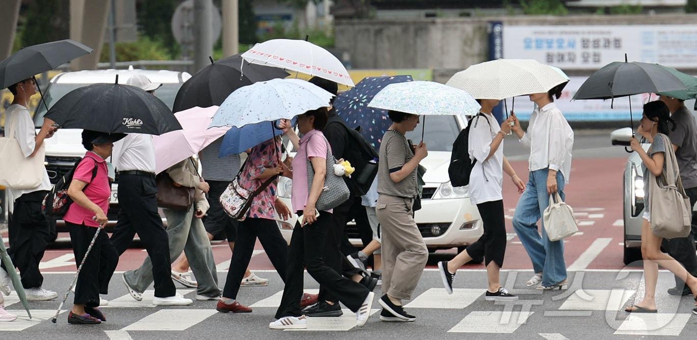 본문 이미지 - 21일 우산 쓴 시민들이 서울 청량리역 앞 횡단보도를 건너고 있다. 2026.8.21 ⓒ 뉴스1 이종덕 기자