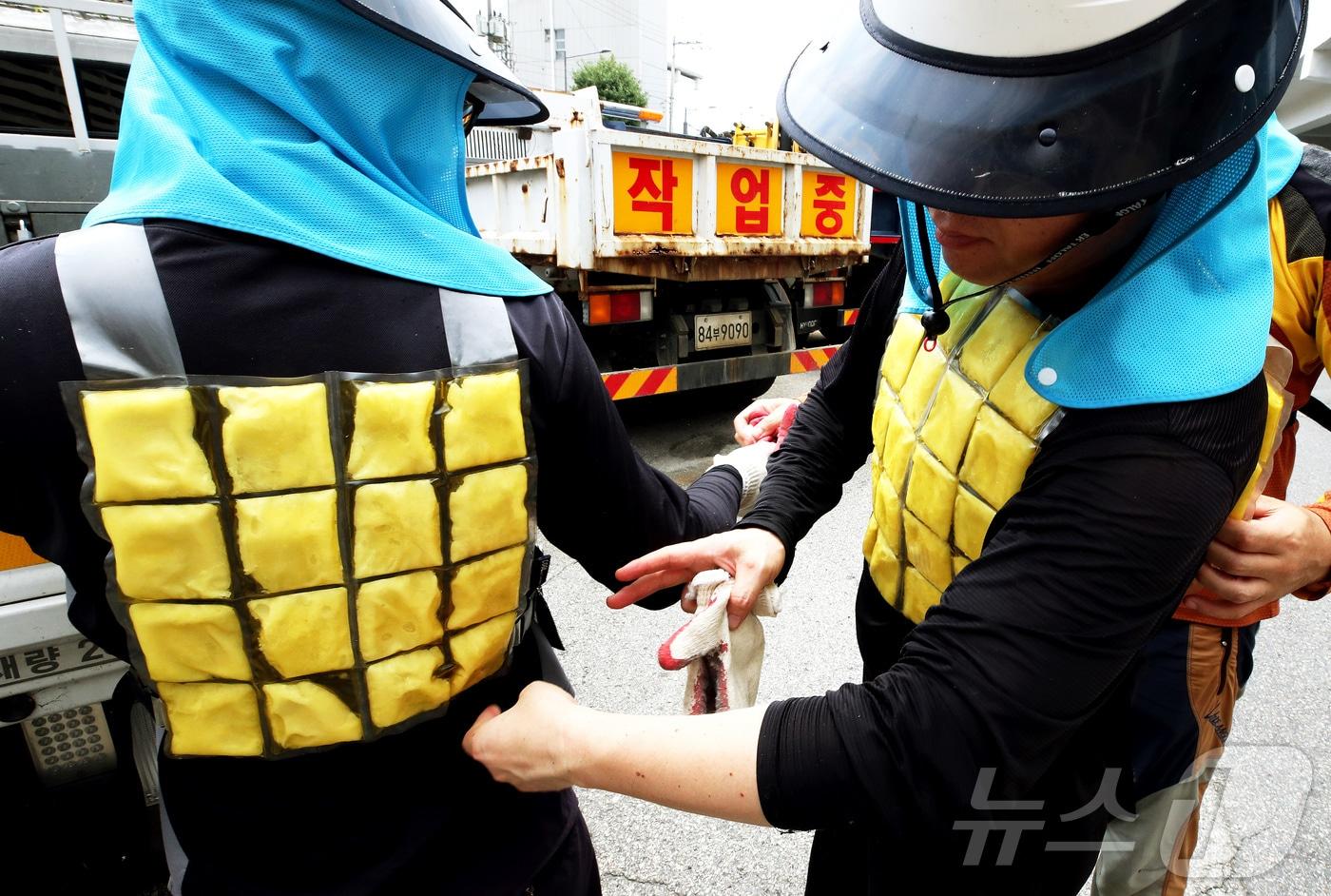 본문 이미지 - 폭염특보가 발효중인 21일 전남광주통합특별시 북구청 공원녹지과 직원들이 차량대기소에서 냉조끼를 착용하고 작업을 준비하고 있다. (전남광주 북구 제공. 재판매 및 DB 금지) 2026.8.21 ⓒ 뉴스1 박지현 기자