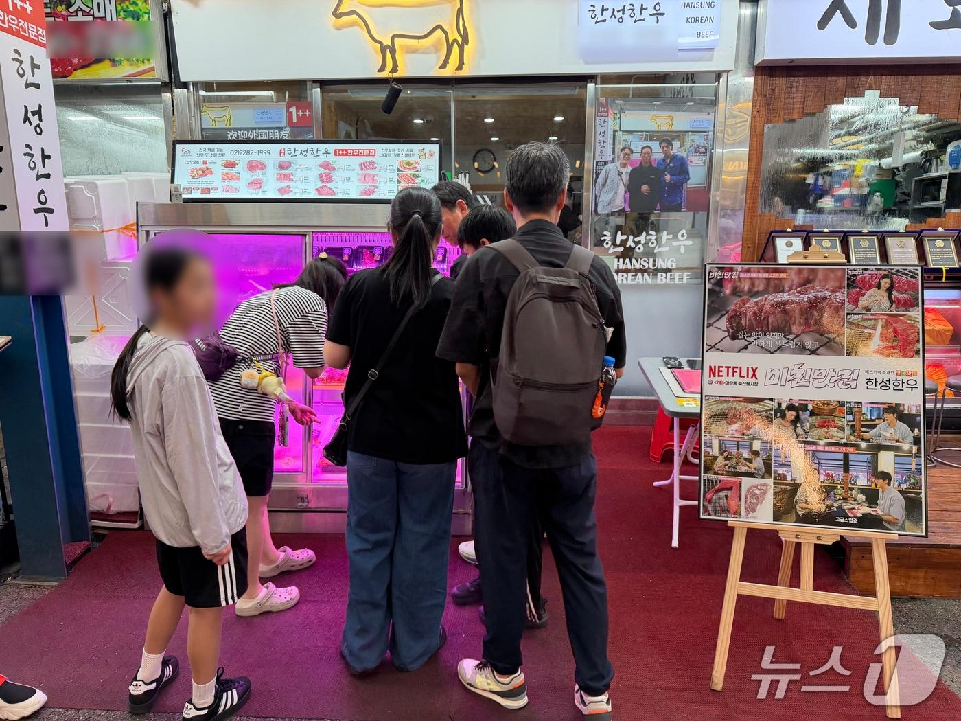 본문 이미지 - 21일 서울 성동구 마장축산물시장에서 마카오에서 온 제이든 일행이 고기를 구입하고 있다. 2026.08.21 ⓒ 뉴스1 권대옥 수습 기자