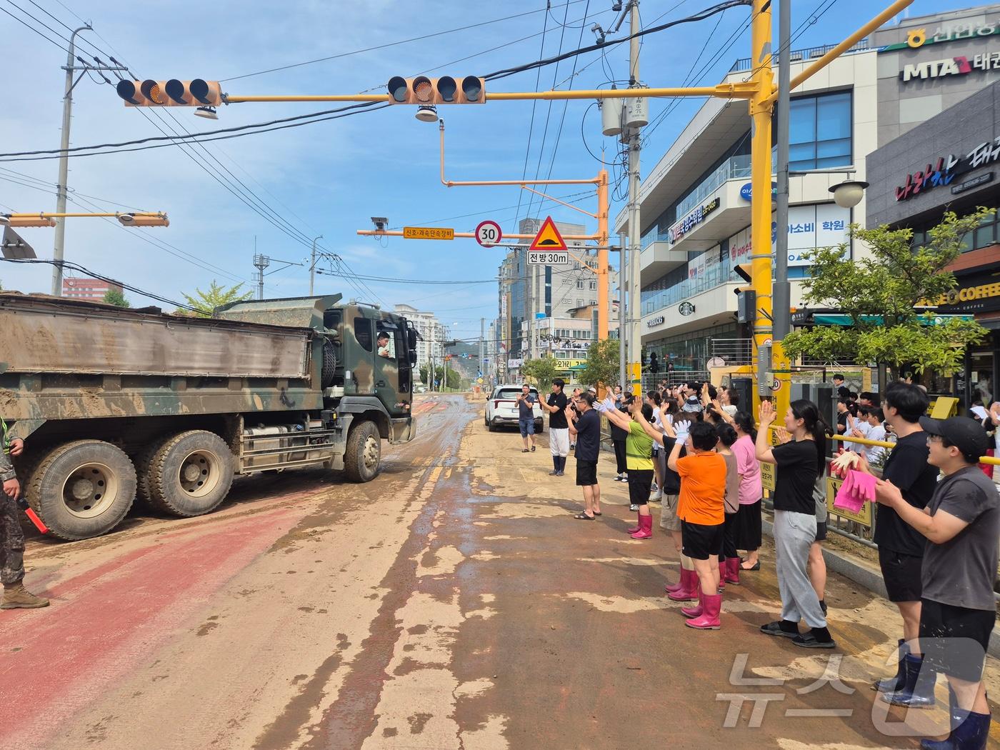 본문 이미지 - 21일 경남 거제시 장평초등학교 교직원, 학부모, 학생 및 장평동 주민들이 장평초에 대민지원을 나왔던 39사단 장병들에게 감사한 마음을 전하며 배웅하고 있다. (육군 제공. 재판매 및 DB 금지) 2026.8.21 ⓒ 뉴스1