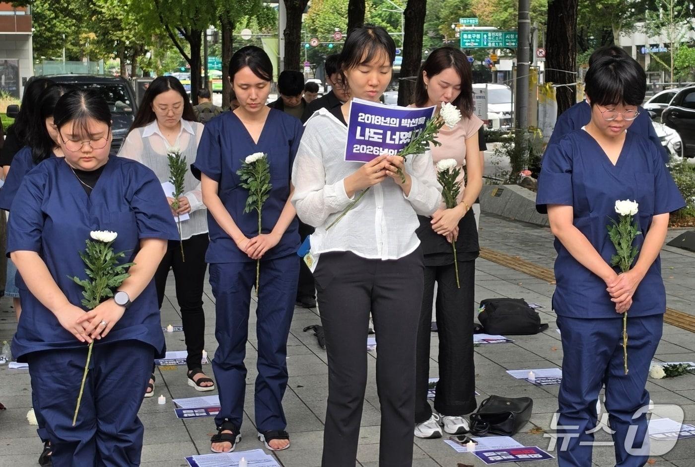 본문 이미지 - 간호사들이 22일 서울 종로구 광화문 교보빌딩 앞에 모여 선배 간호사의 폭언·모욕 등 직장 내 괴롭힘을 뜻하는 이른바 '태움'으로 숨진 동료들을 추모하고, 안전한 간호환경 마련을 촉구했다. 2026.8.22 ⓒ 뉴스1 권준언 기자