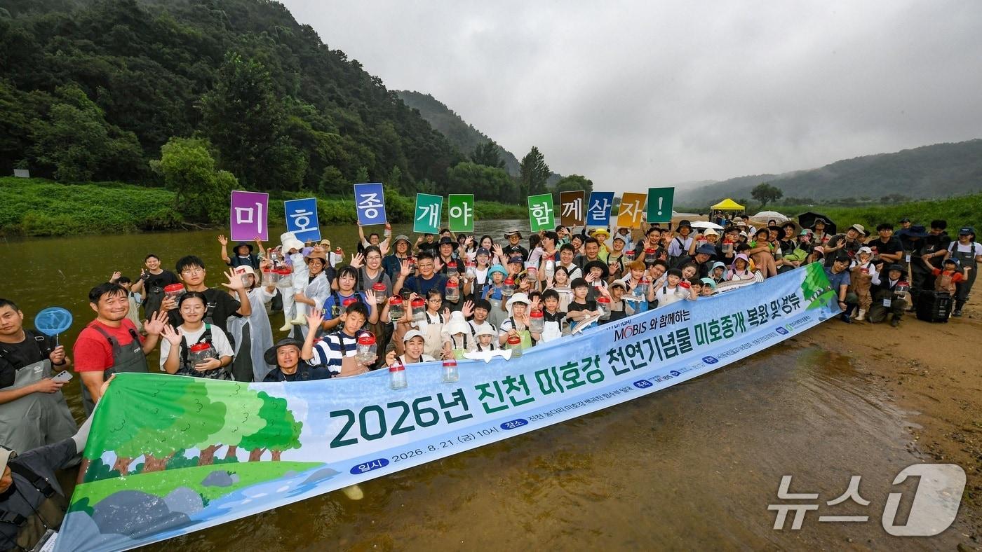 본문 이미지 - 현대모비스 임직원과 가족들이 충북 진천군 미호강 일대에서 천연기념물 미호종개 치어를 방류하고 있는 모습. (현대모비스 제공)
