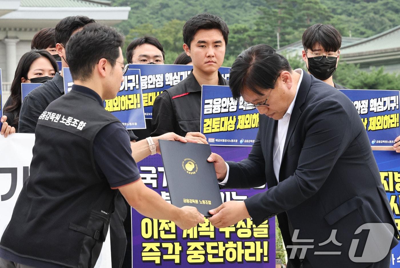 본문 이미지 - 금융감독원과 예금보험공사 노동조합 관계자들이 24일 오전 서울 종로구 청와대 분수대 앞에서 금융감독기관 지방이전 반대 공동 기자회견을 한 뒤 청와대 국민경청비서관실 직원에게 의견서를 전달하고 있다. 2026.8.24 ⓒ 뉴스1 이종수 기자