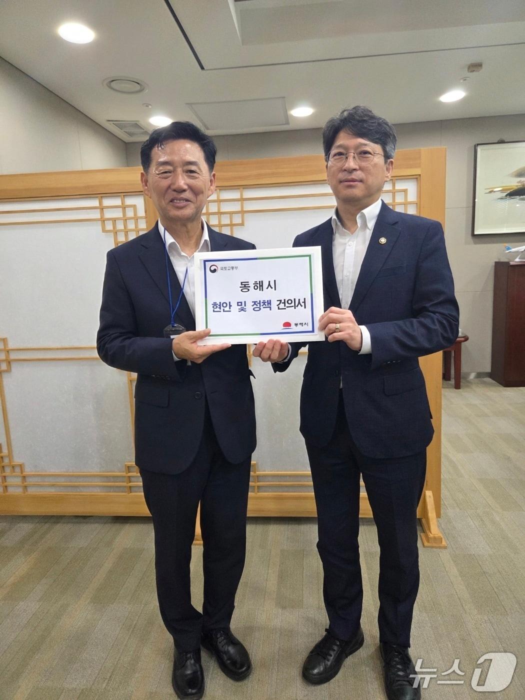 본문 이미지 - 이정학 강원 동해시장이 24일 홍지선 국토교통부 2차관에게 지역 현안과 정책 건의서를 전달하고 있다.(동해시 제공, 재판매 및 DB 금지) 2026.8.24/뉴스1