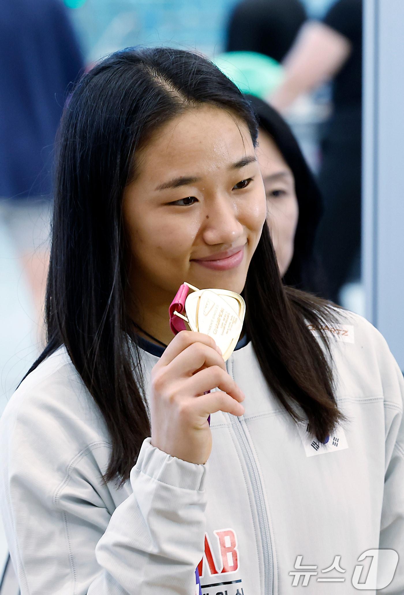 본문 이미지 - 2026 세계배드민턴연맹(BWF) 세계선수권대회 여자 단식을 제패한 안세영이 25일 오전 인천국제공항을 통해 귀국해 메달을 들어 보이고 있다. 세계랭킹 1위 안세영은 지난 23일(한국시간) 인도 뉴델리에서 열린 2026 세계배드민턴연맹(BWF) 세계선수권대회 여자단식 결승에서 야마구치 아카네(2위·일본)를 49분 만에 게임 스코어 2-0(21-17 21-14)으로 제압하며 지난 2023년 우승 이후 3년 만에 다시 세계선수권 정상에 올랐다. 2026.8.25 ⓒ 뉴스1 박정호 기자
