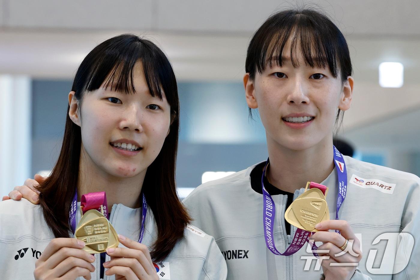 본문 이미지 - 세계선수권대회 여자복식 우승을 차지한 이소희(오른쪽)와 백하나가 25일 오전 인천국제공항을 통해 귀국해 메달을 들어 보이고 있다. 2026.8.25 ⓒ 뉴스1 박정호 기자