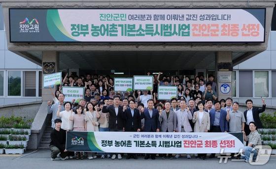 본문 이미지 - 지난 6월 11일 전북 진안군이 농어촌 기본소득 시범사업 대상지로 선정된 직후 전춘성 군수와 공무원, 사회단체, 주민 등이 기념 촬영을 하고 있다.(진안군 제공. 재판매 및 DB금지)/뉴스1