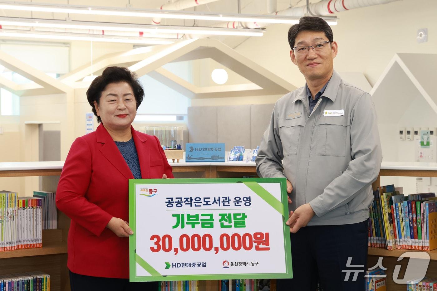 본문 이미지 - HD현대중공업 이준엽 상생·총무부문장(오른쪽)과 천기옥 울산 동구청장(왼쪽)이 25일 책놀이터 북적북적에서 기부금 전달식을 가지고 기념사진을 찍고 있다.(울산 동구 제공. 재판매 및 DB금지)/뉴스1