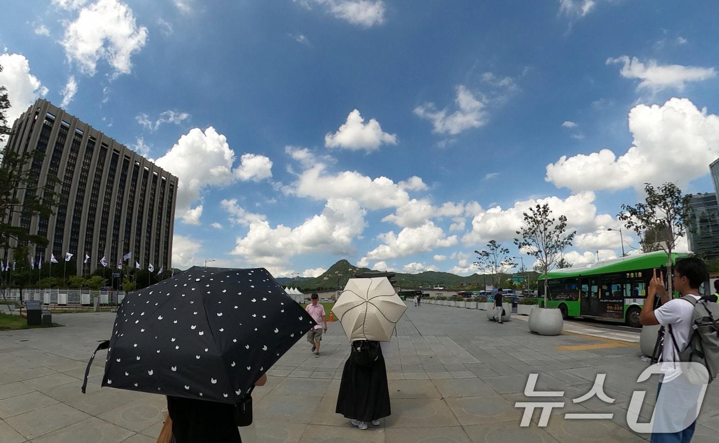 본문 이미지 - 25일 서울 종로구 광화문광장에서 관광객들이 양산을 쓰고 이동하고 있다.  2026.8.25 ⓒ 뉴스1 김명섭 기자