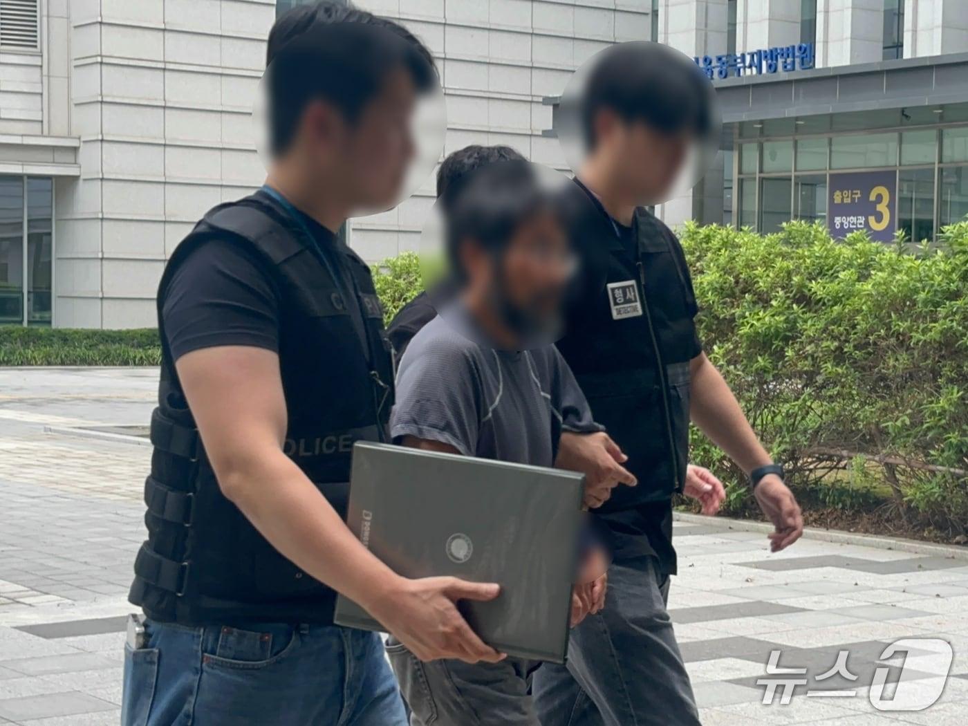 본문 이미지 - 서울 송파구 올림픽공원 개표소 봉쇄 시위 현장에서 다른 참가자를 폭행한 혐의를 받는 50대 남성이 25일 구속 전 피의자 심문(영장실질심사)을 위해 법원에 출석하는 모습. 2026.8.25 ⓒ 뉴스1 강서연 기자