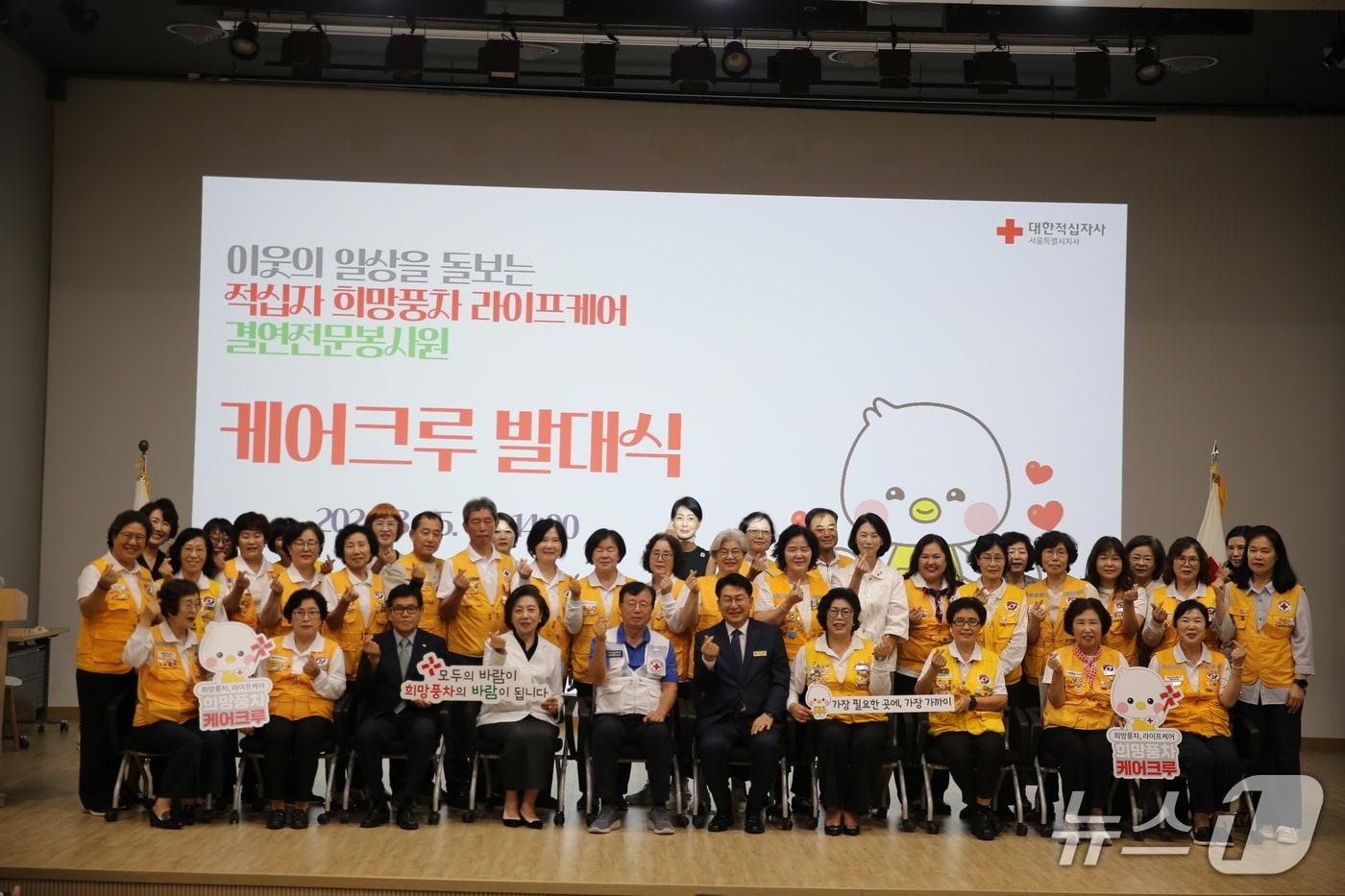 본문 이미지 - 지난 25일 성동구 대한적십자사 서울지사 나눔홀에서 열린 '희망풍차 케어크루 발대식'에서 권영규 서울지사회장(앞줄 왼쪽에서 다섯번째)과 유보화 성동구청장(앞줄 왼쪽에서 여섯 번째)을 비롯한 케어크루 봉사원들이 단체 기념촬영을 하고 있다.(대한적십자사 서울지사 제공)