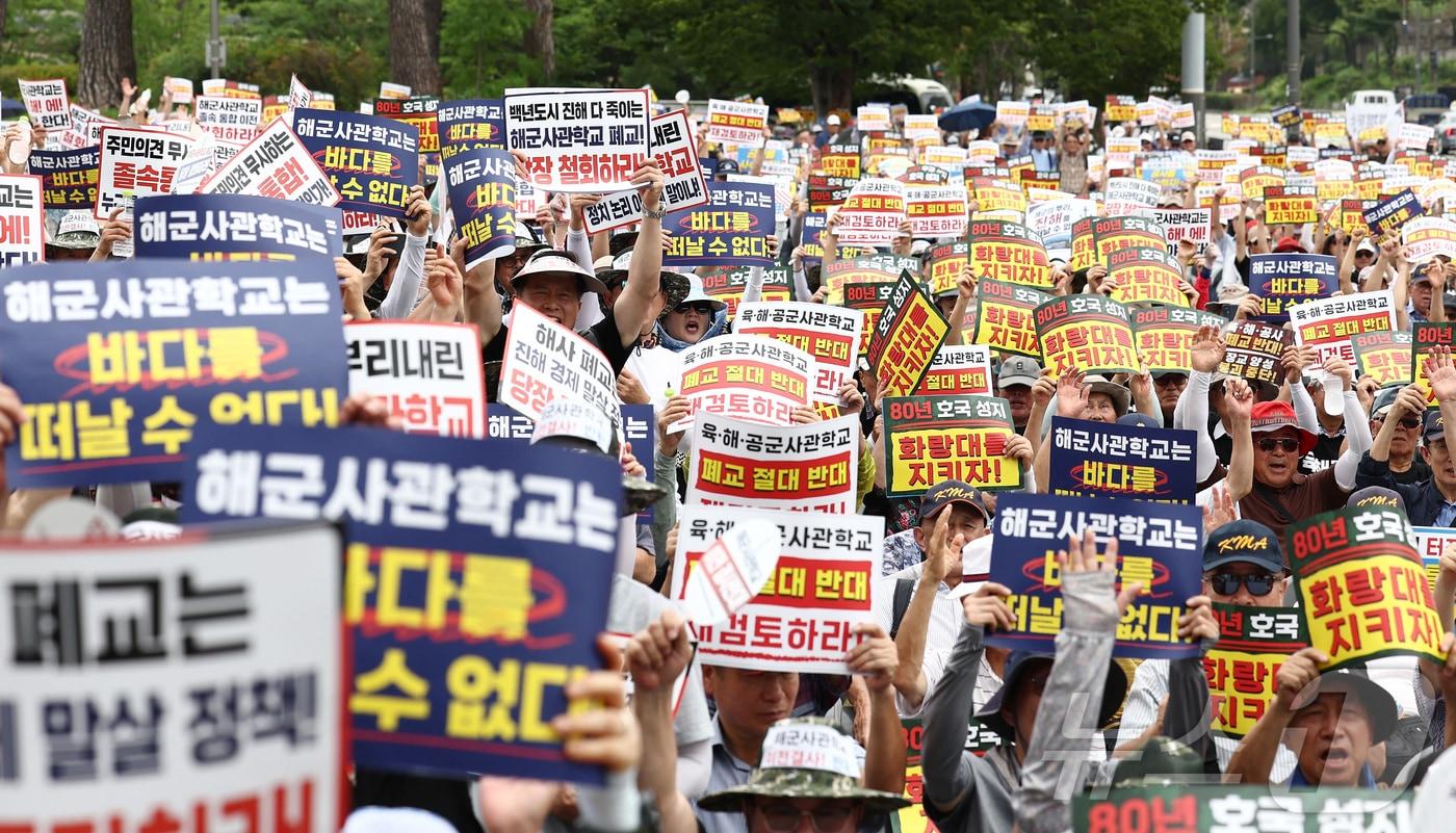 본문 이미지 - 육·해·공 사관학교 통합형인 '국군사관학교' 창설 관련 공청회가 열린 26일 오후 서울 용산구 전쟁기념관 앞에서 열린 육·해·공 사관학교 통폐합 반대 집회에서 참석자들이 사관학교 통폐합에 반대하는 손팻말을 들고 구호를 외치고 있다. 2026.8.26 ⓒ 뉴스1 김민지 기자