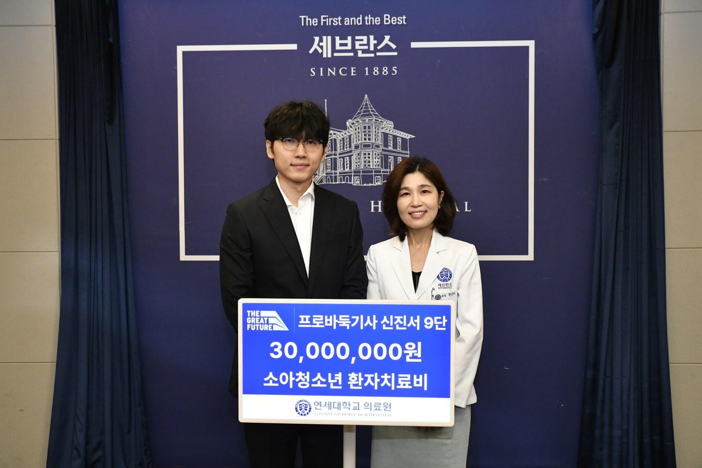 본문 이미지 - 신진서 9단(쪽)과 천근아 세브란스 어린이병원장이 기부금 전달식을 마치고 사진 촬영을 하고 있다.(한국기원 제공)