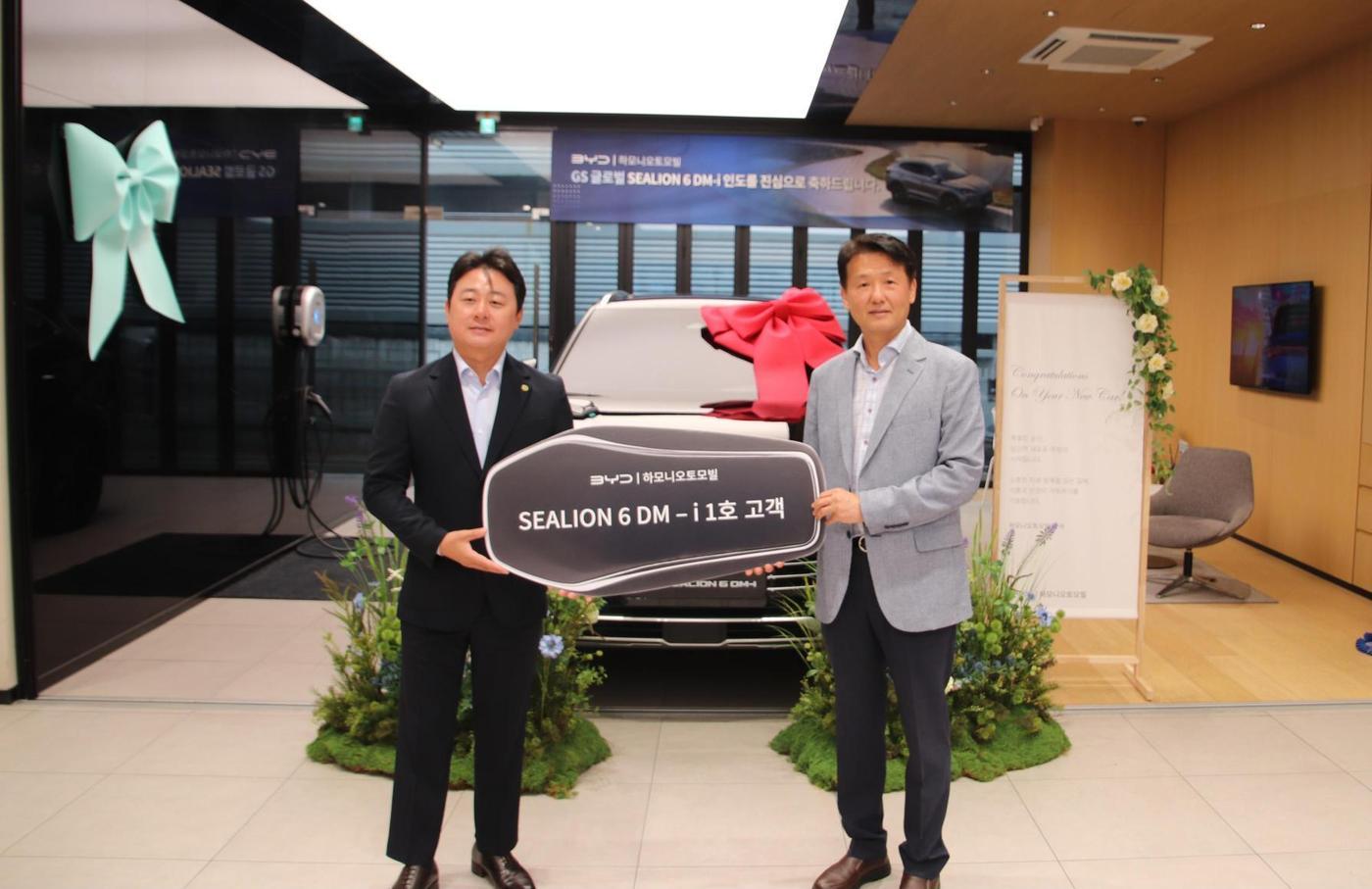 본문 이미지 - GS글로벌은 BYD 코리아가 최근 국내에 선보인 플러그인 하이브리드(PHEV) SUV 모델 '씨라이언 6 DM-i'의 국내 1호 고객으로 차량 인수식을 진행했다고 27일 밝혔다. 왼쪽부터 BYD 코리아 공식 딜러사인 하모니오토모빌 마린영 대표와 GS글로벌 에코솔루션사업부 김의수 상무. (GS글로벌 제공)