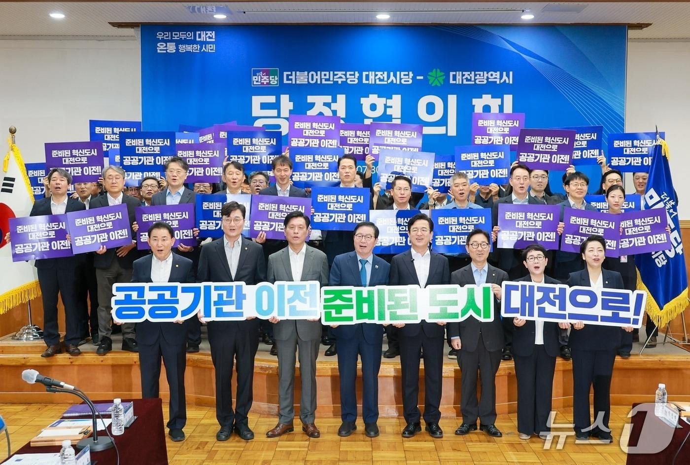 본문 이미지 - 허태정 대전시장과 민주당 소속 대전지역 7명의 극회의원이 지난 13일 옛 충남도청 대회의실에서 당정협의회를 갖기 전 공공기관 이전을 기원하는 퍼포먼스를 하고 있다. (대전시 제공) / 뉴스1