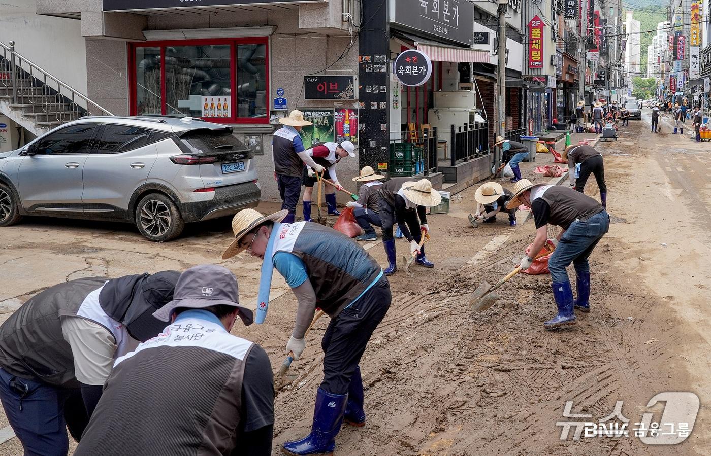 본문 이미지 - 지난 19일 BNK금융그룹 임직원들이 수해 현장에서 복구작업을 돕는 모습 (BNK금융 제공. 재판매 및 DB금지)