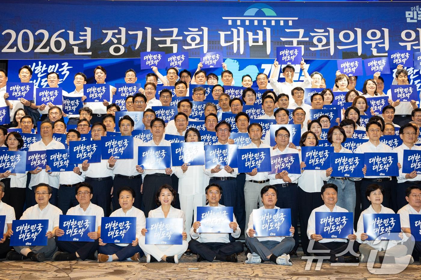 본문 이미지 - 김민석 더불어민주당 대표를 비롯한 의원들이 27일 인천 영종구 인스파이어 엔터테인먼트 리조트에서 열린 2026년 정기국회 대비 국회의원 워크숍에서 손팻말을 들고 구호를 외치고 있다. 2026.8.27 ⓒ 뉴스1 유승관 기자