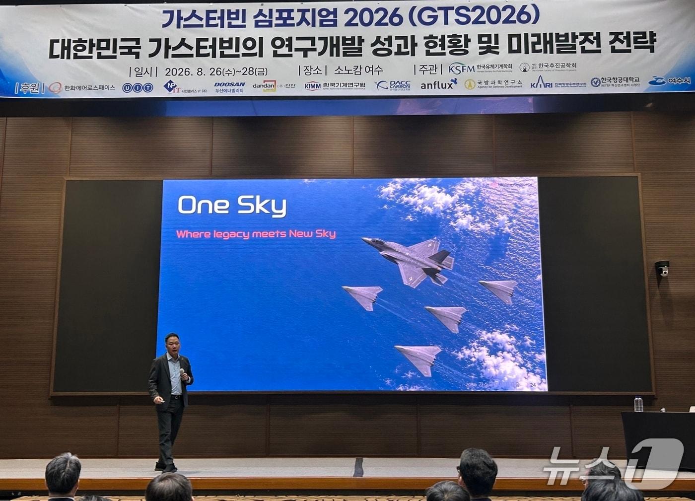 본문 이미지 - 27일 전남 여수시에서 진행된 '가스터빈 심포지엄 2026'에서 김선 한화에어로스페이스 부사장이 미래 항공엔진 개발 패러다임 '원 스카이(One Sky)'를 설명하고 있다.(한화 제공)