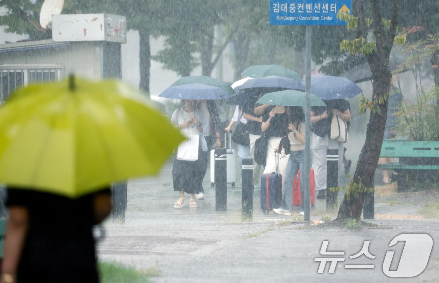 본문 이미지 - 28일 전남광주통합특별시 서구 김대중컨벤션센터 앞에서 시민들이 우산으로 비를 피하며 발걸음을 재촉하고 있다. 2026.8.28 ⓒ 뉴스1 김태성 기자