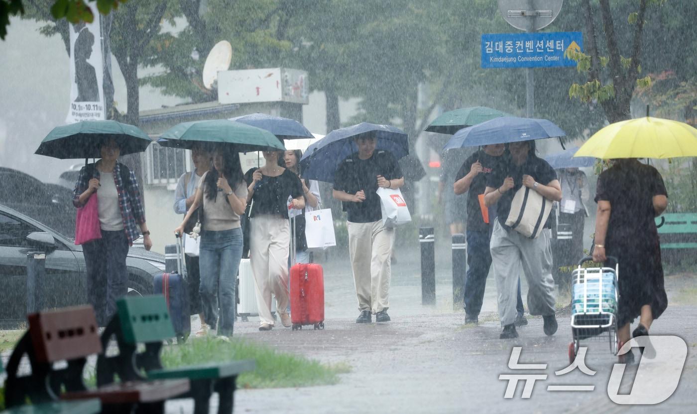 본문 이미지 - 28일 전남광주통합특별시 서구 김대중컨벤션센터 앞에서 시민들이 우산으로 비를 피하며 발걸음을 재촉하고 있다. ⓒ 뉴스1 김태성 기자