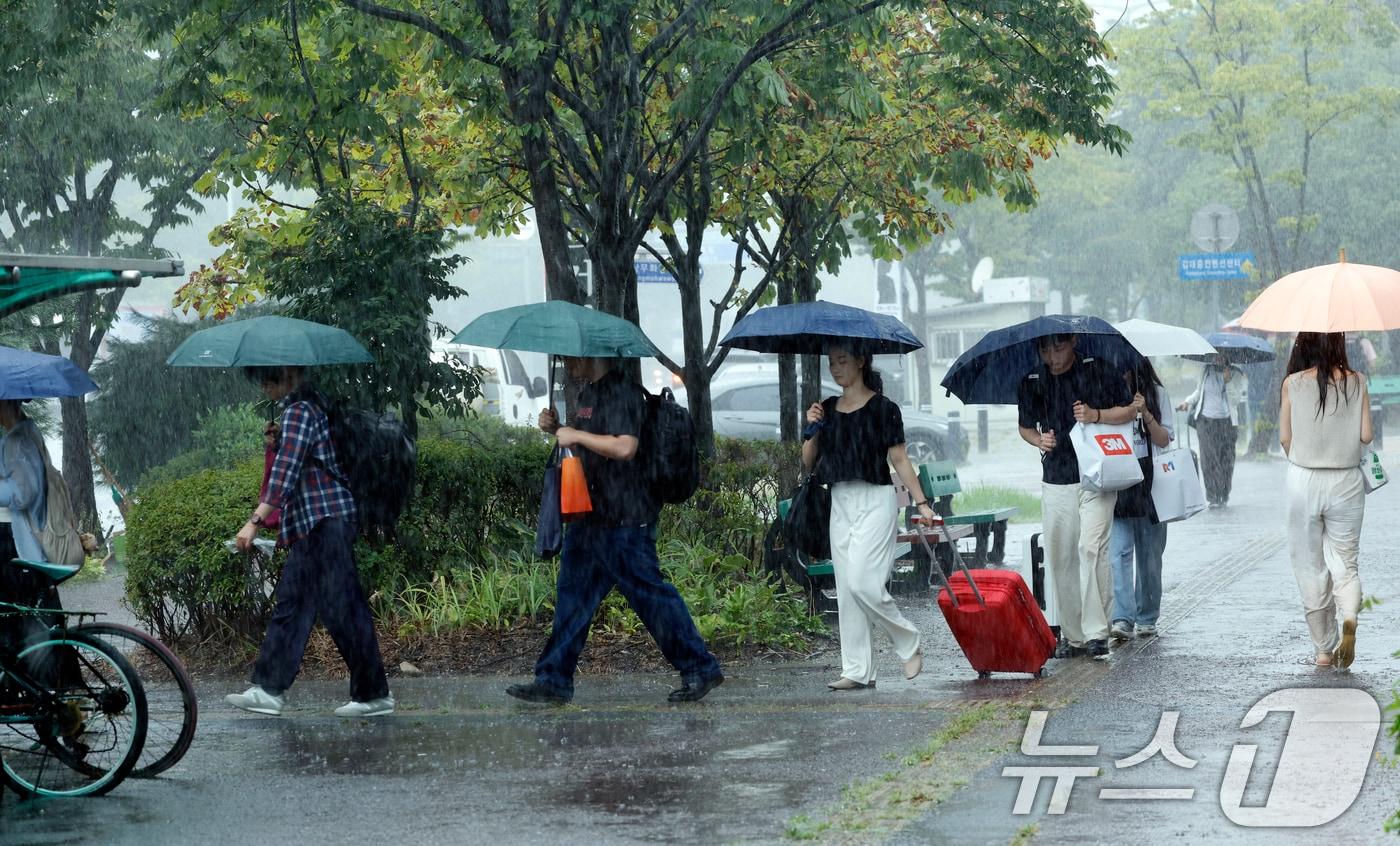 본문 이미지 - 28일 전남광주통합특별시 서구 김대중컨벤션센터 앞에서 시민들이 우산으로 비를 피하며 발걸음을 재촉하고 있다. 2026.8.28 ⓒ 뉴스1 김태성 기자