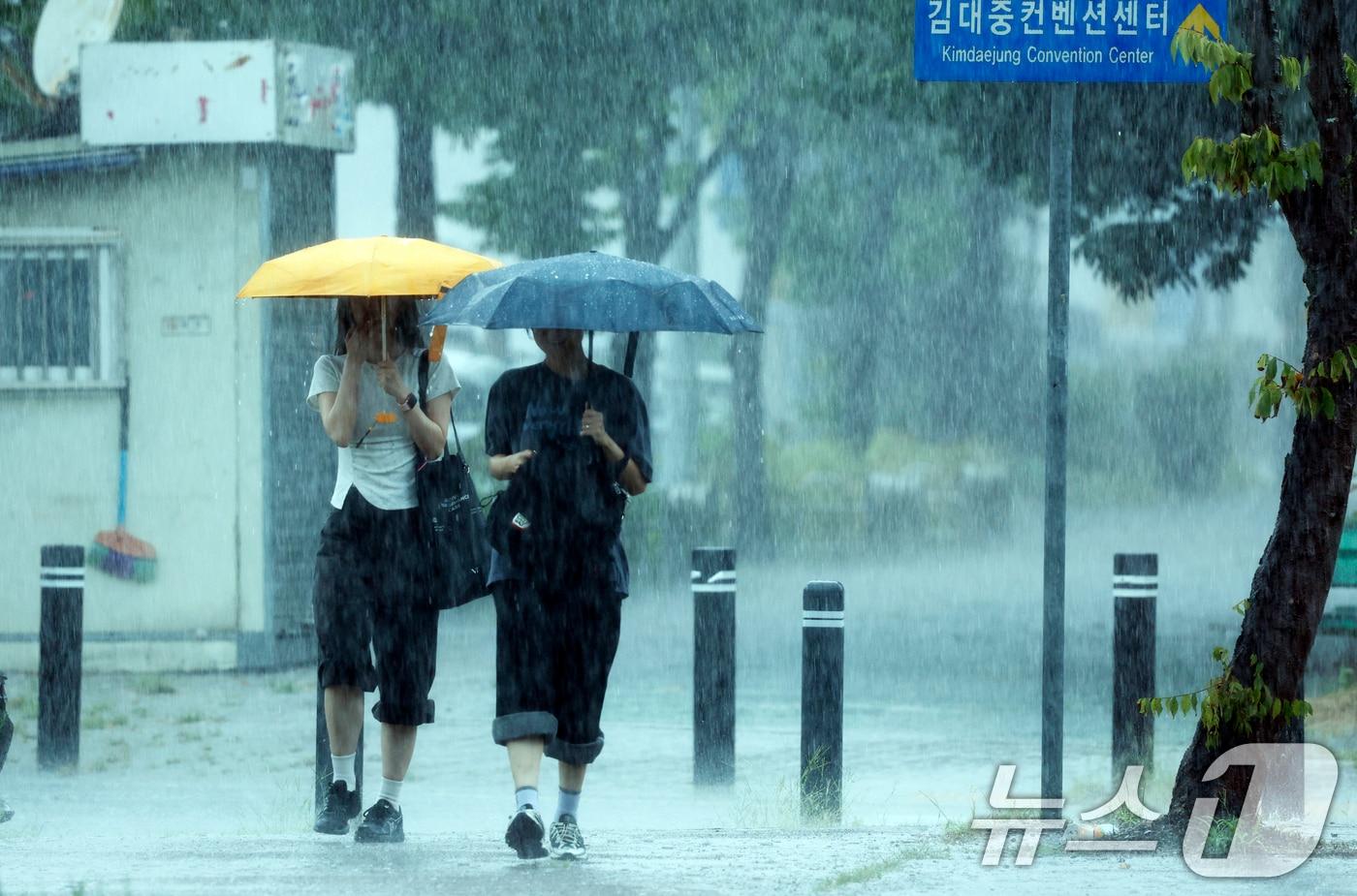 본문 이미지 - 28일 전남광주통합특별시 서구 김대중컨벤션센터 앞에서 시민들이 우산으로 비를 피하며 발걸음을 재촉하고 있다. 2026.8.28 ⓒ 뉴스1 김태성 기자