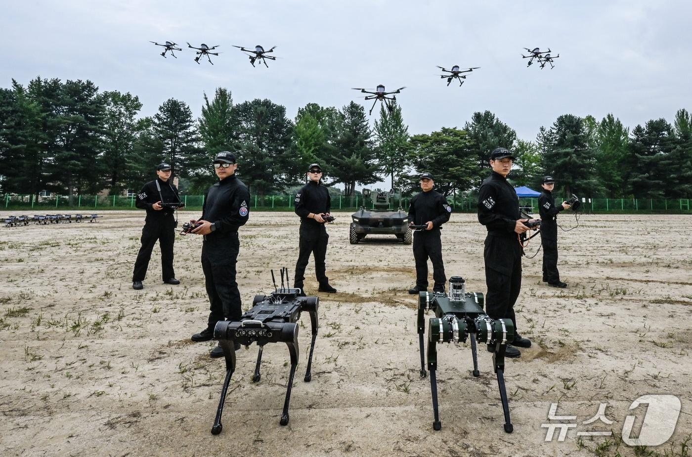 본문 이미지 - 육군정보학교 산하 드론·로봇 전술시범단 소속 장병들과 시범단에서 운용하는 다족보행로봇, 드론 등 장비 모습. 2026.8.28./ⓒ 뉴스1(육군 제공)