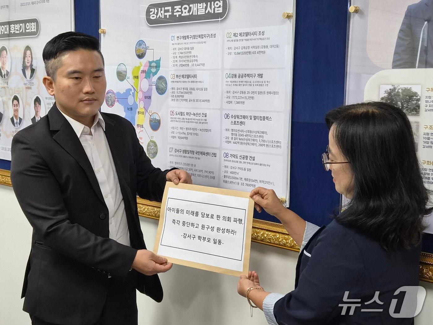 본문 이미지 - 최훈기 북부교육지원청 학교학부모연합회장(왼쪽)이 28일 부산강서구의회 사무처에 성명서를 제출하고 있다. 2026.8./28뉴스1 ⓒ News1 임순택 기자