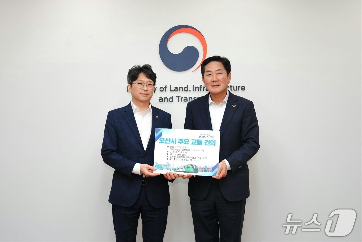 본문 이미지 -  조용호 경기 오산시장(오른쪽)이 28일 서울 국토발전전시관에서 홍지선 국토교통부 제2차관을 만나 오산시 주요 교통 현안을 건의한 뒤 기념촬영을 하고 있다. (오산시 제공)