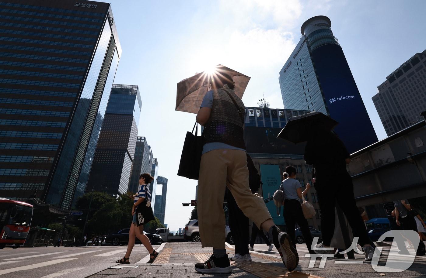 본문 이미지 - 서울 광화문네거리에서 양산을 쓴 시민들이 횡단보도를 걷고 있다. 2026.8.3 ⓒ 뉴스1 구윤성 기자