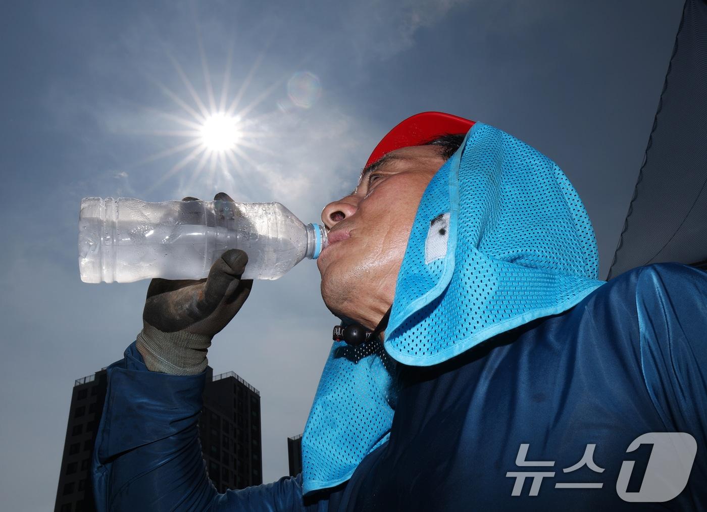본문 이미지 - 전국 대부분 지역에 폭염특보가 내려진 3일 경기 화성시의 한 공사현장에서 근로자가 물을 마시며 더위를 식히고 있다. 2026.8.3 ⓒ 뉴스1 김영운 기자