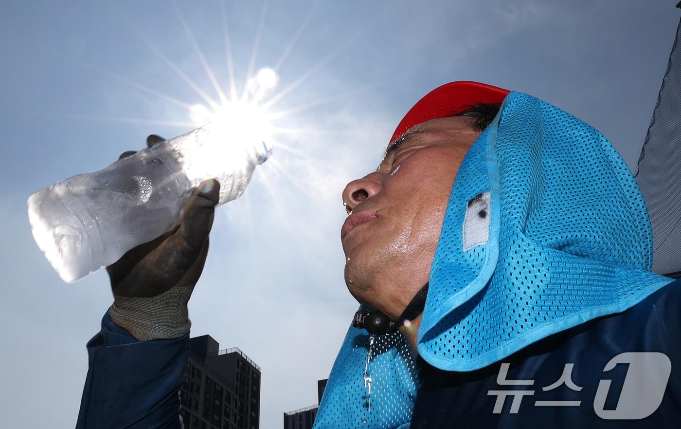 본문 이미지 - 전국 대부분 지역에 폭염특보가 내려진 3일 경기 화성시의 한 공사현장에서 근로자가 물을 마시며 더위를 식히고 있다. 2026.8.3 ⓒ 뉴스1 김영운 기자