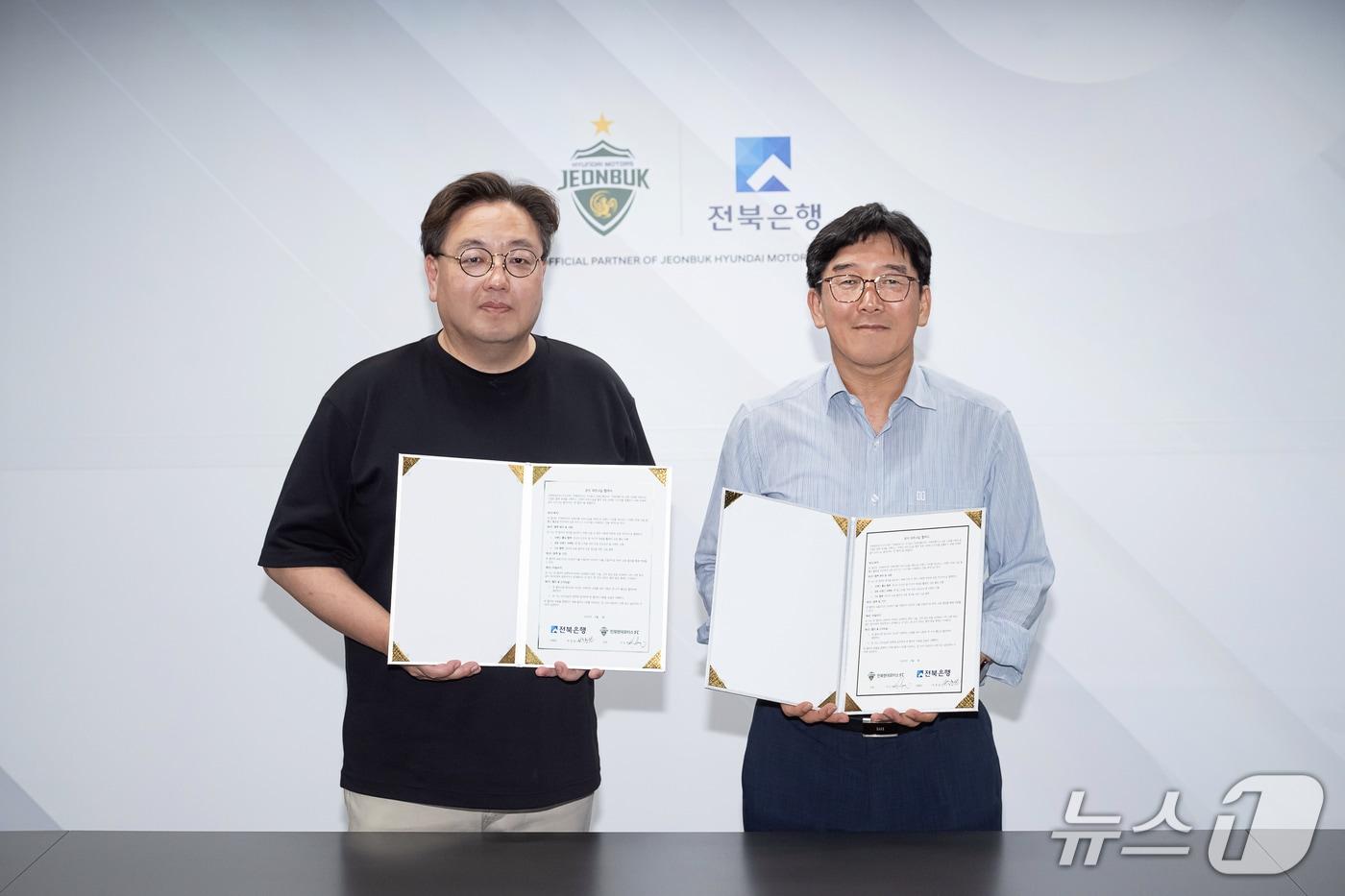 본문 이미지 - 지난 1일 전주월드컵경기장에서 열린 전북현대 홈경기에서 전북은행과 전북현대가 파트너십 협약식을 가진 가운데 박춘원 전북은행장(오른쪽)과 전북현대모터스FC 이도현 단장이 기념촬영을 하고 있다.(전북은행 제공. 재판매 및 DB 금지)