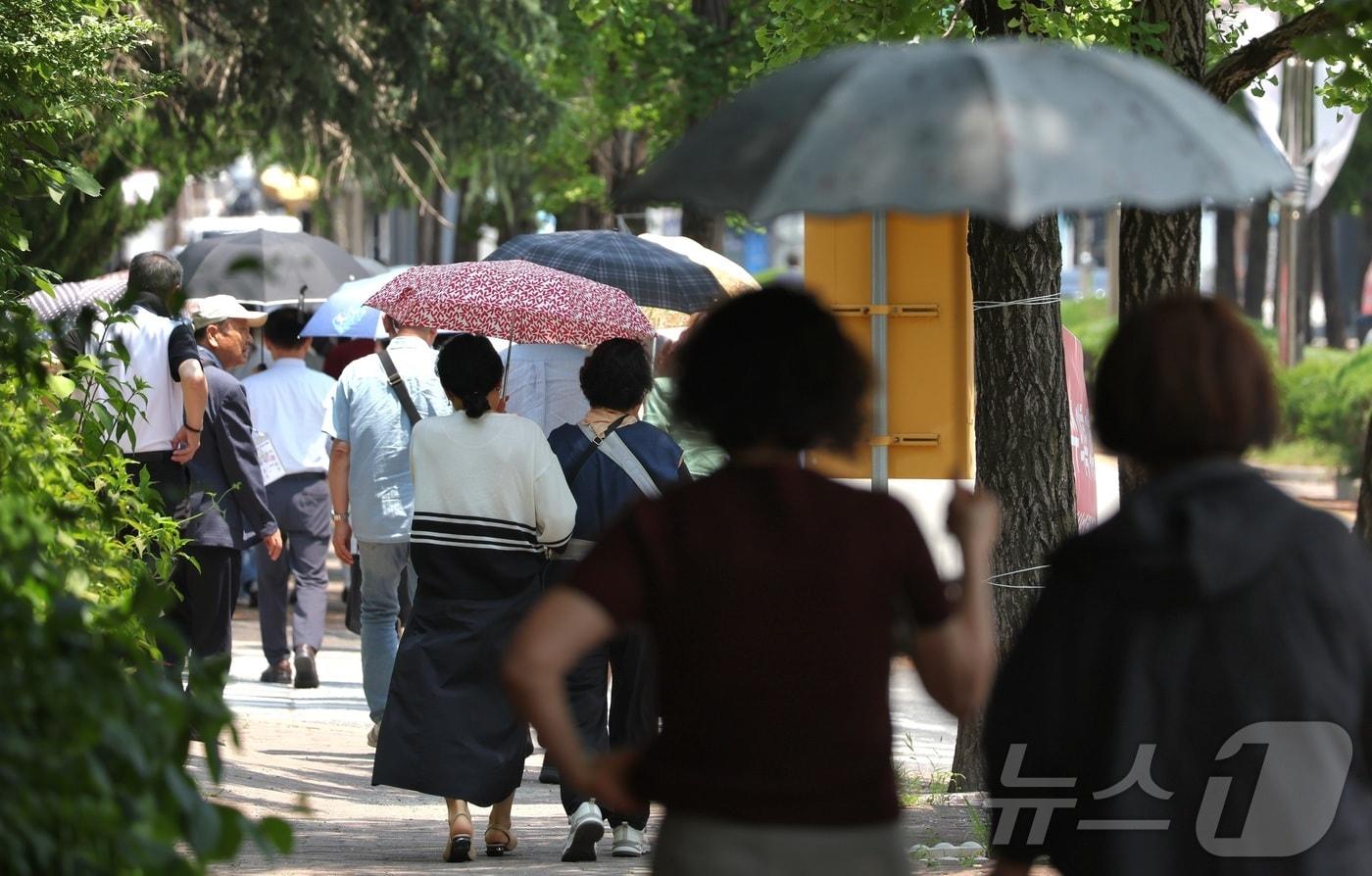 본문 이미지 - 연일 폭염이 기승을 부리고 있는 3일 전북 전주시 전주대학교에서 양산을 쓴 시민들이 발걸음을 옮기고 있다. 2026.8.3 ⓒ 뉴스1 유경석 기자