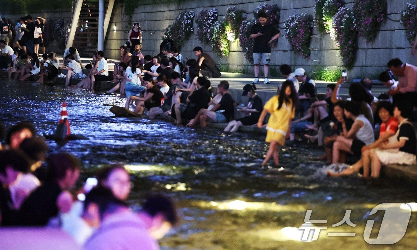 본문 이미지 - 밤사이 최저기온이 25도를 웃도는 열대야가 이어진 3일 밤 서울 청계천을 찾은 시민들이 산책하며 더위를 식히고 있다. 2026.8.3 ⓒ 뉴스1 이종수 기자