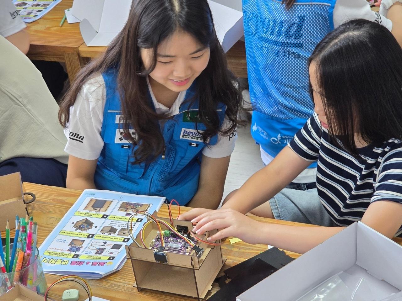본문 이미지 - 인천 지역아동센터 아동이 비욘드 19기 단원이 개발한 '나만의 Color Key로 만드는 AI 금고' 공학 키트를 활용해 회로를 연결하며 공학 원리를 체험하고 있다. (포스코 제공)