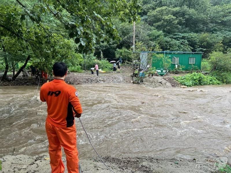 본문 이미지 - 30일 오후 전남광주 화순군 한천면 죽헌로 일대에서 호우로 범람한 계곡물에 도로가 침수되자 소방대원들이 고립된 주민들을 구조하고 있다.(전남광주통합소방본부 제공. 재판매 및 DB금지)