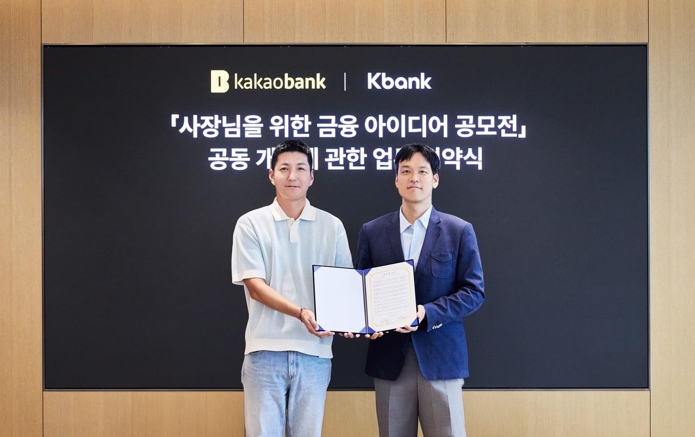 본문 이미지 - 김성수 카카오뱅크 여신본부장(오른쪽)과 김민찬 케이뱅크 Corporate그룹장이 지난 28일 경기도 성남시 카카오뱅크 판교오피스에서 진행된 '사장님을 위한 금융 아이디어 공모전' 업무협약식에 참여해 기념촬영을 하고 있다.(카카오뱅크 제공). 