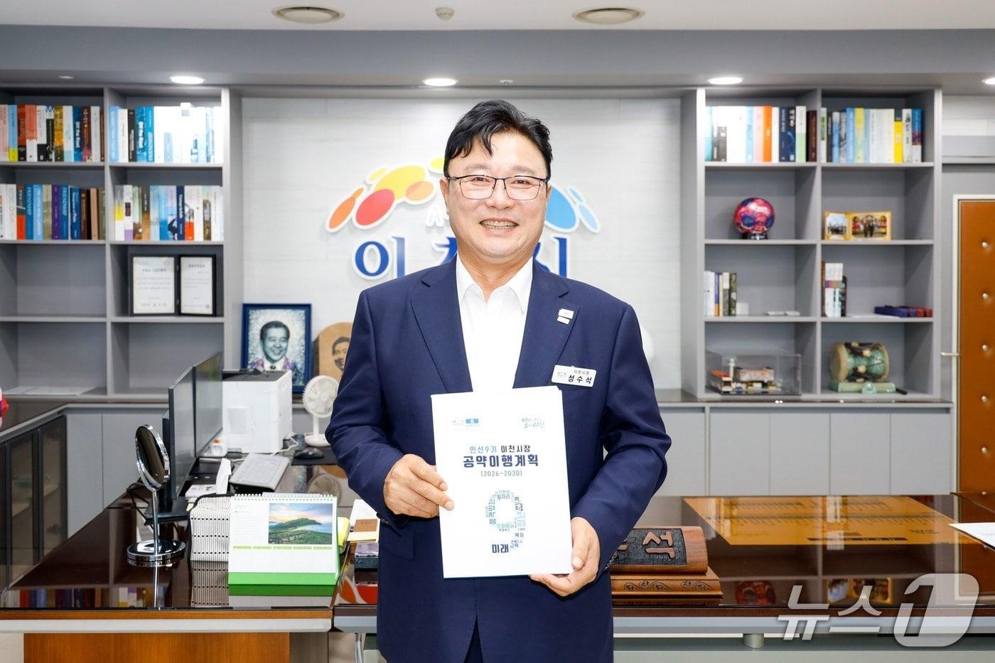 본문 이미지 - 성수석 시장이 '민선9기 공약이행계획서'를 들고 기념촬영을 하고 있는 모습.(이천시 제공)