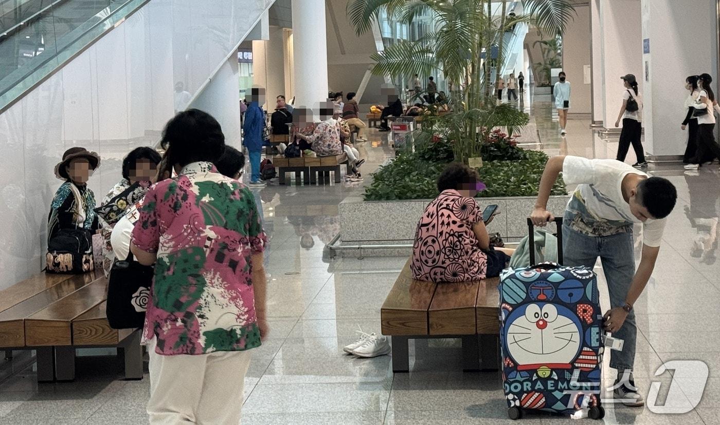 본문 이미지 - 4일 오후 찾은 인천국제공항 제2여객터미널. 여행용 캐리어를 끄는 승객들 사이로 부채를 부치는 노인들이 눈에 띄었다.2026.8.4/뉴스1