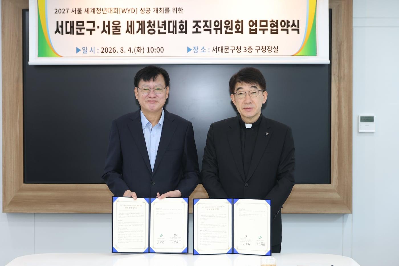 본문 이미지 - 박운기(왼쪽) 서대문구청장과 김현 신부가 협약서에 서명한 후 기념 촬영을 하고 있다.(서대문구 제공)