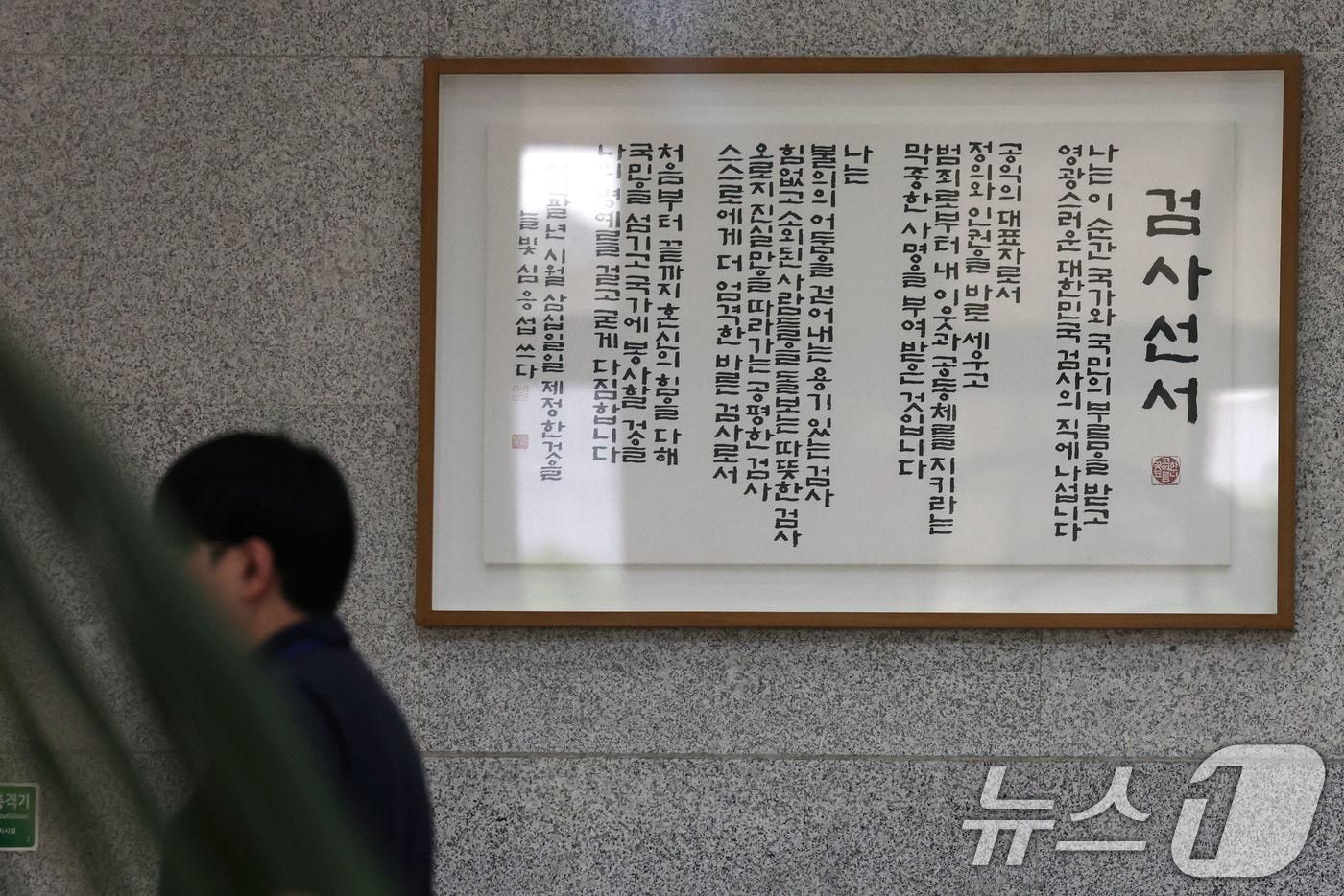 본문 이미지 - 5일 서울 서초구 서울중앙지방검찰청 로비에 걸린 검사선서문 앞을 관계자가 지나고 있다. 행정안전부 중대범죄수사청(중수청) 개청준비단은 이날부터 12일까지 전국 18개 지방검찰청 등을 돌며 검사와 검찰 수사관을 대상으로 임용설명회를 개최한다. 또 7일부터 20일까지 임용 희망 신청을 받아 9월말까지 대상자를 선정하고 10월 2일 중수청 출범에 맞춰 임용할 예정이다. 2026.8.5 ⓒ 뉴스1 이광호 기자