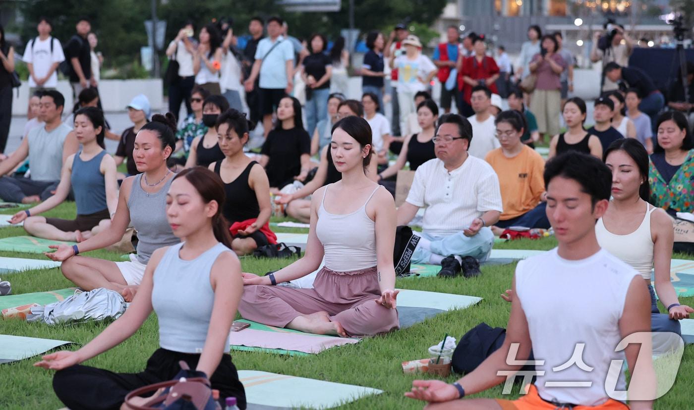 본문 이미지 - 5일 서울 광화문광장에서 열린 '광화문 달빛요가'에 참가한 시민들이 요가를 하며 몸과 마음의 휴식을 취하고 있다. 2026.8.5 ⓒ 뉴스1 박지혜 기자