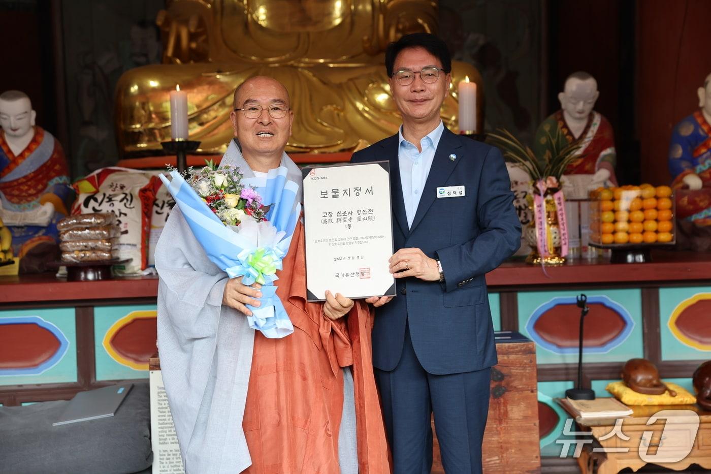 본문 이미지 - 심덕섭 고창군수(사진 오른쪽)가 6일 운천 선운사 부주지 스님에게 영산전 보물지정서를 전달하고 있다.(고창군 제공. 재판매 및 DB 금지)