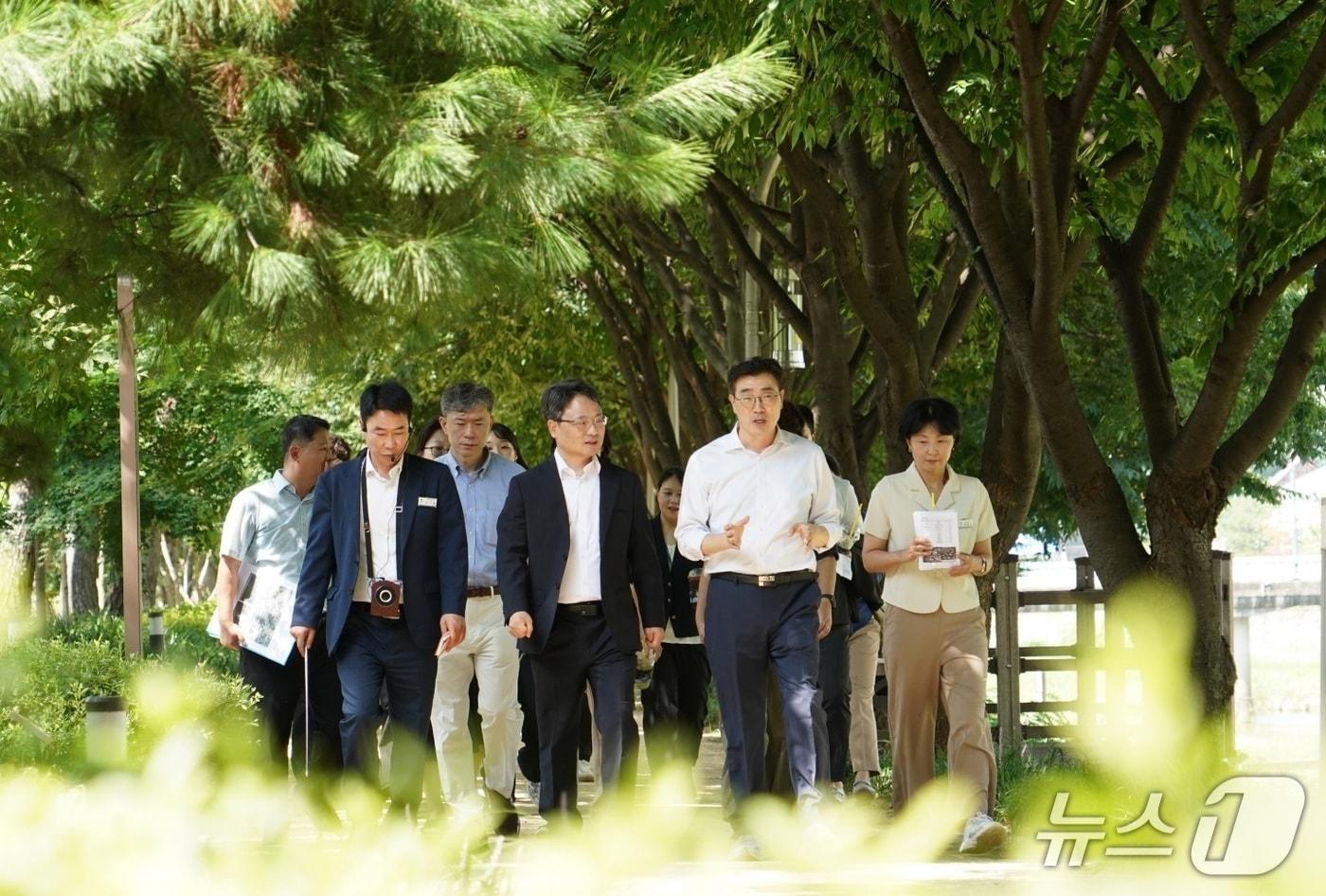 본문 이미지 - 박은식 산림청장(앞줄 가운데)과 최원용 평택시장(앞줄 오른쪽)이 6일 평택 도시바람길숲을 방문해 폭염 저감 효과와 관리 방안에 대해 논의하고 있다(산림청 제공. 재판매 및 DB금지)/뉴스1