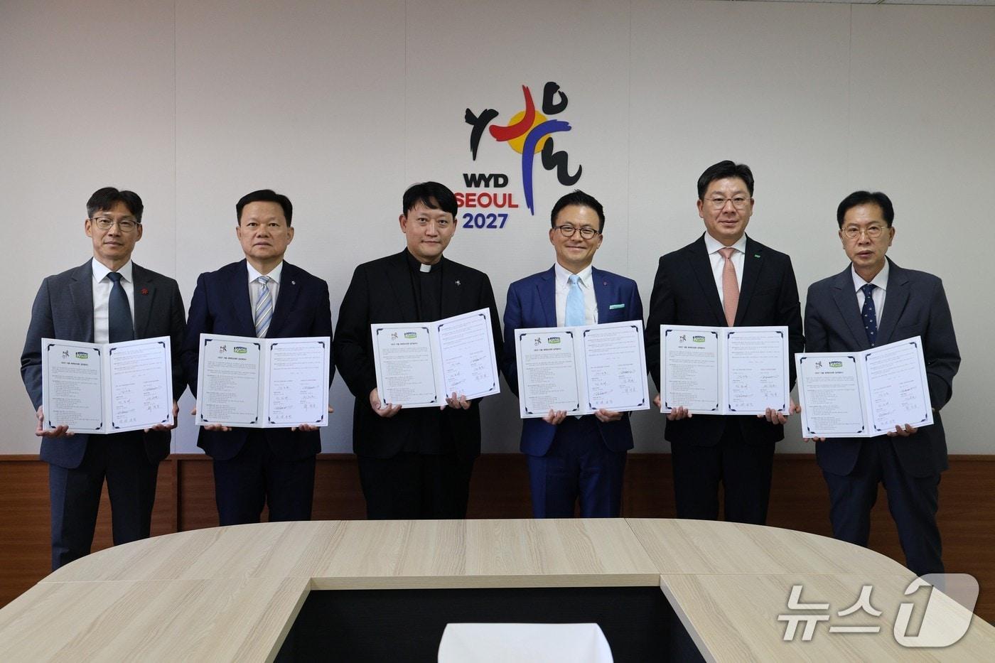 본문 이미지 - 6일 천주교 서울대교구청에서 열린 한국편의점산업협회-2027 서울 세계청년대회 조직위원회 업무협약식에서 관계자들이 기념촬영을 하고 있다. (왼쪽부터) 최진일 이마트24 대표, 정춘호 지에스25 편의점비즈니스유닛장, 김남균 사무국장(신부), 김대일 편의점산업협회장, 민승배 비지에프리테일 대표, 씨스페이스24 김동원 전무(편의점산업협회 제공). 2026.8.7/뉴스1